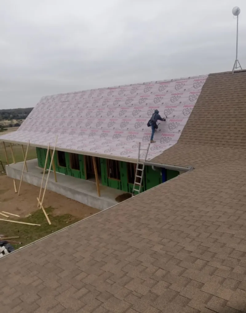Worker preparing underlayment for a metal roof installation in Fort Walton Beach